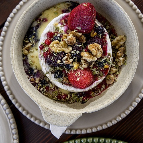a bowl of food with berries and walnuts on top