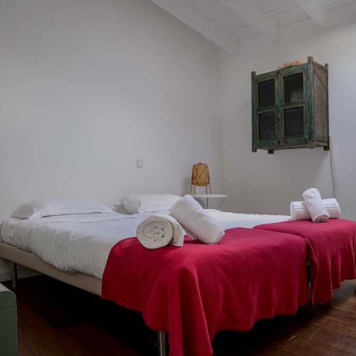 Aldeia da Pedralva hotel room with two beds and red throws.
