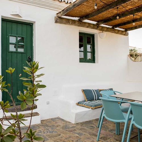 Aldeia da Pedralva: charming patio with blue chairs, table, and green door.