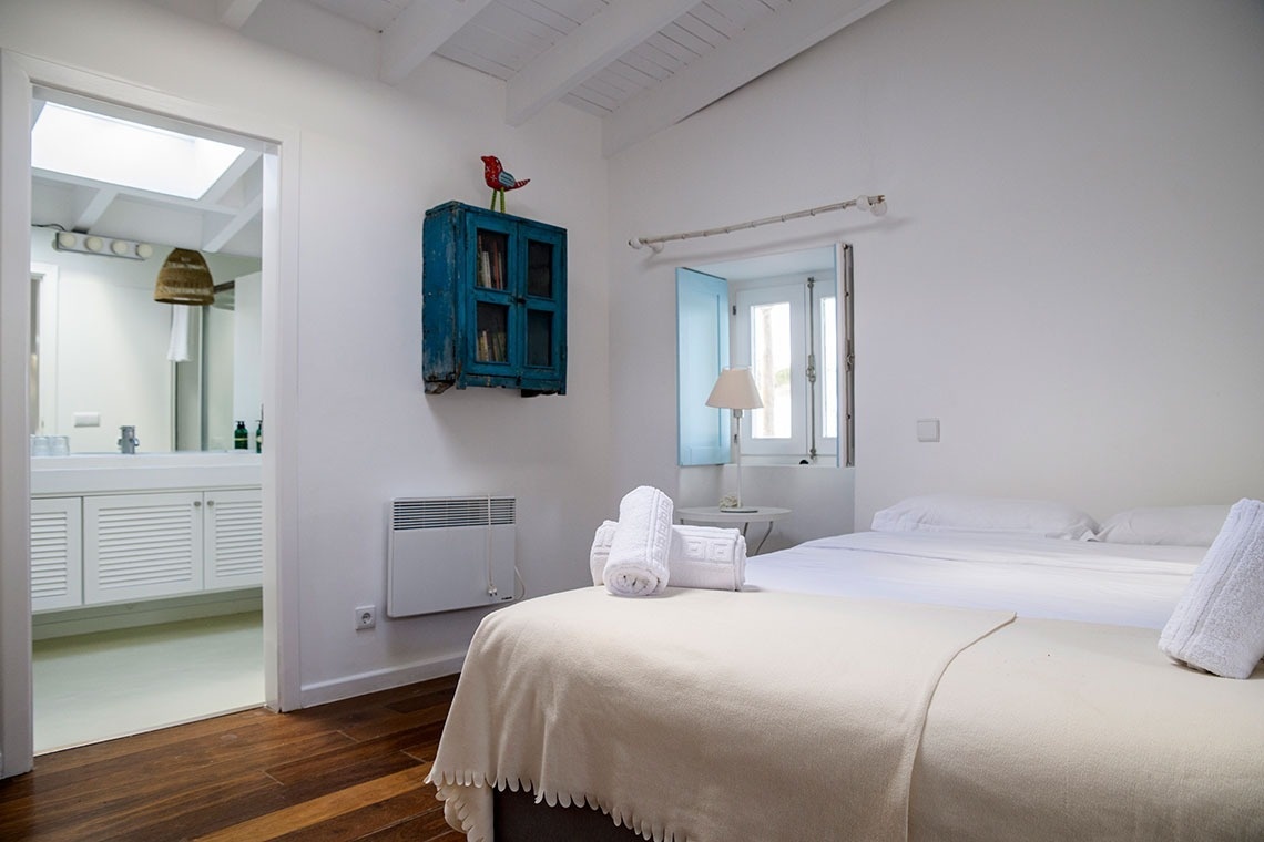 un dormitorio con dos camas y un armario azul en la pared