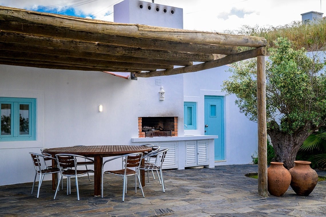 un patio con una mesa y sillas y una parrilla
