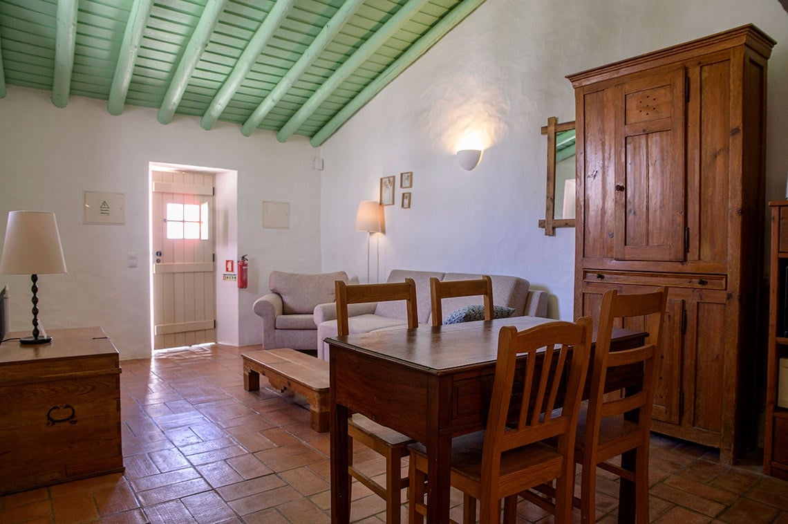Sala aconchegante na Aldeia da Pedralva com mobiliário rústico de madeira.