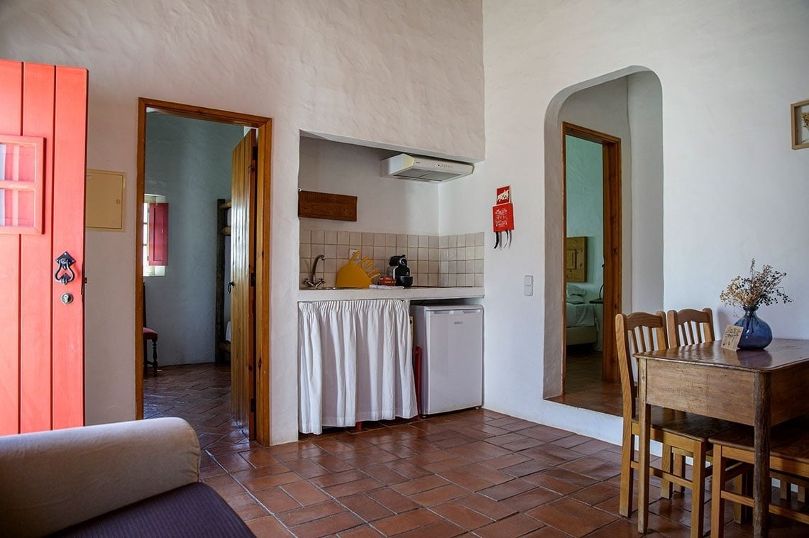 una puerta roja conduce a una cocina pequeña