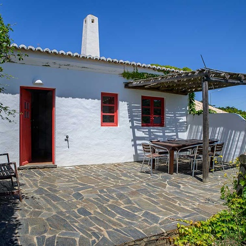 Outdoor dining patio with table and chairs at Aldeia da Pedralva.