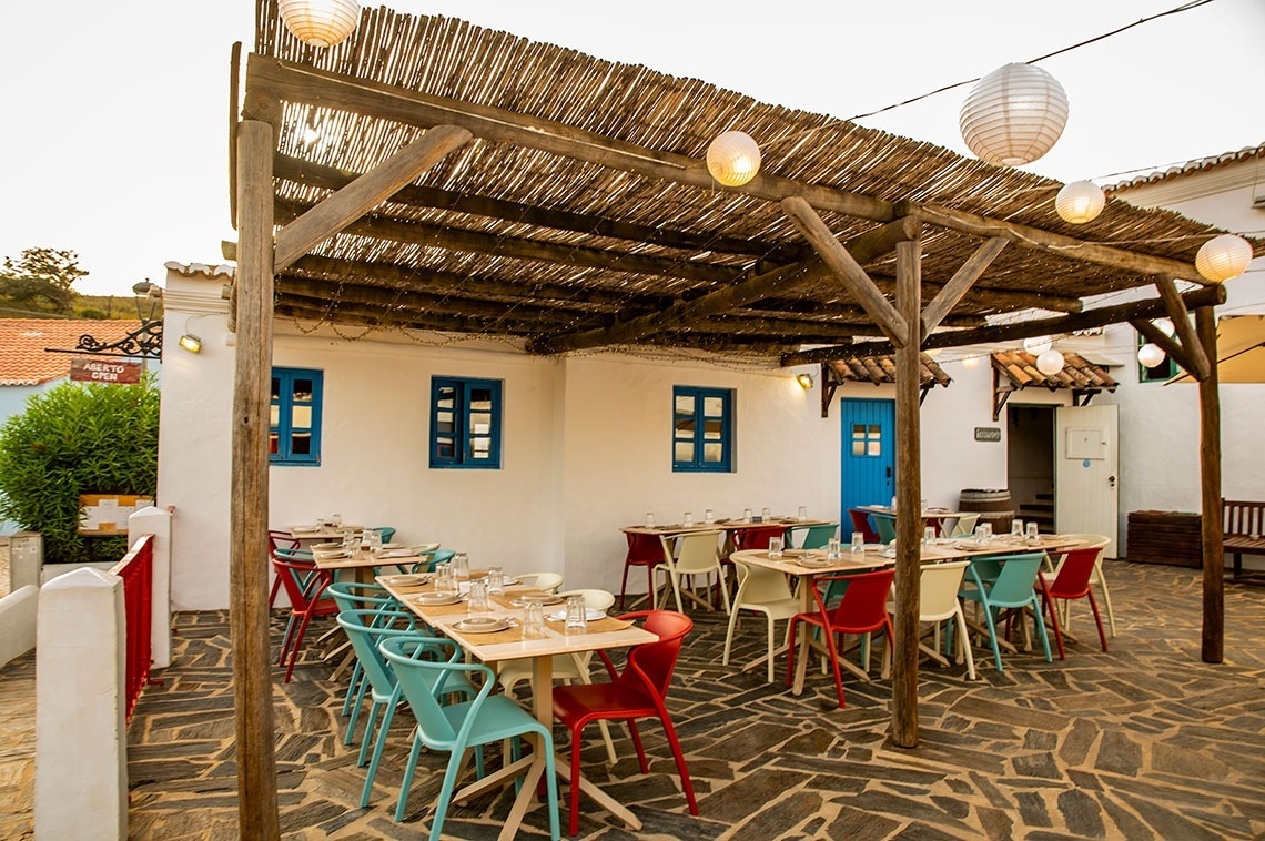 a narrow alleyway between two white houses with red tile roofs