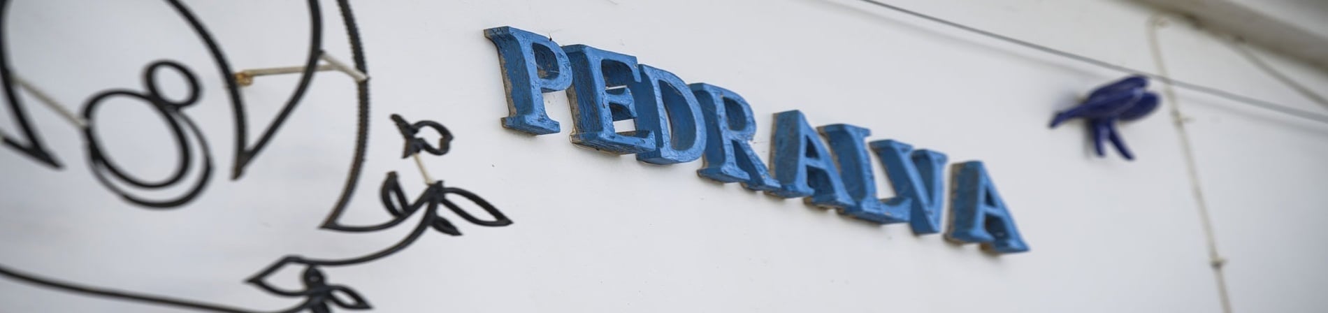 una pared blanca con letras azules que dicen pedrava