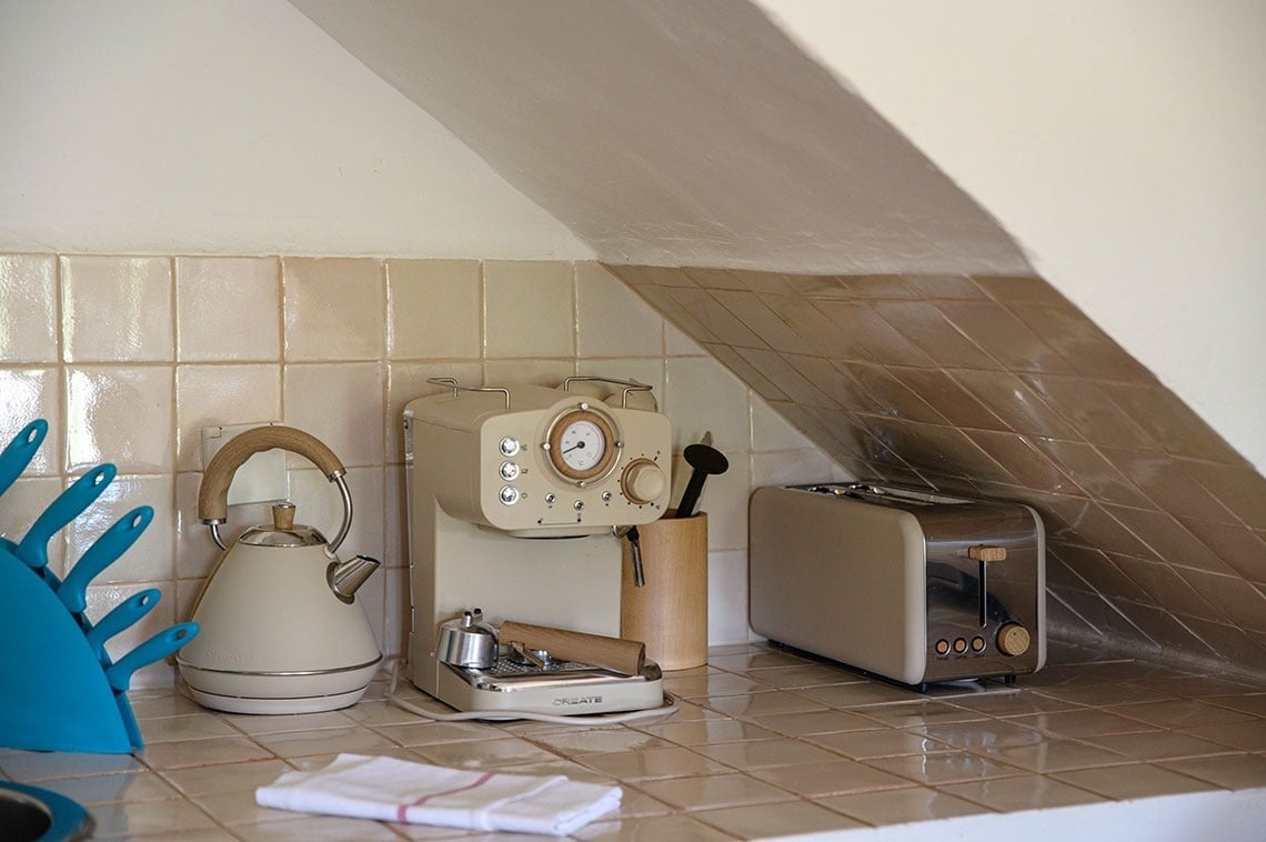 una tostadora y una cafetera están en una cocina