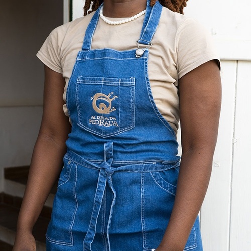 a woman wearing a denim apron that says g on it