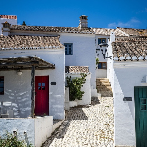 a white house with a red door and a green door