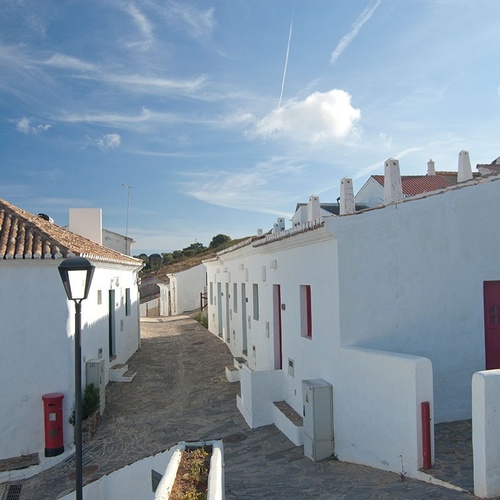 una calle llena de casas blancas con puertas rojas