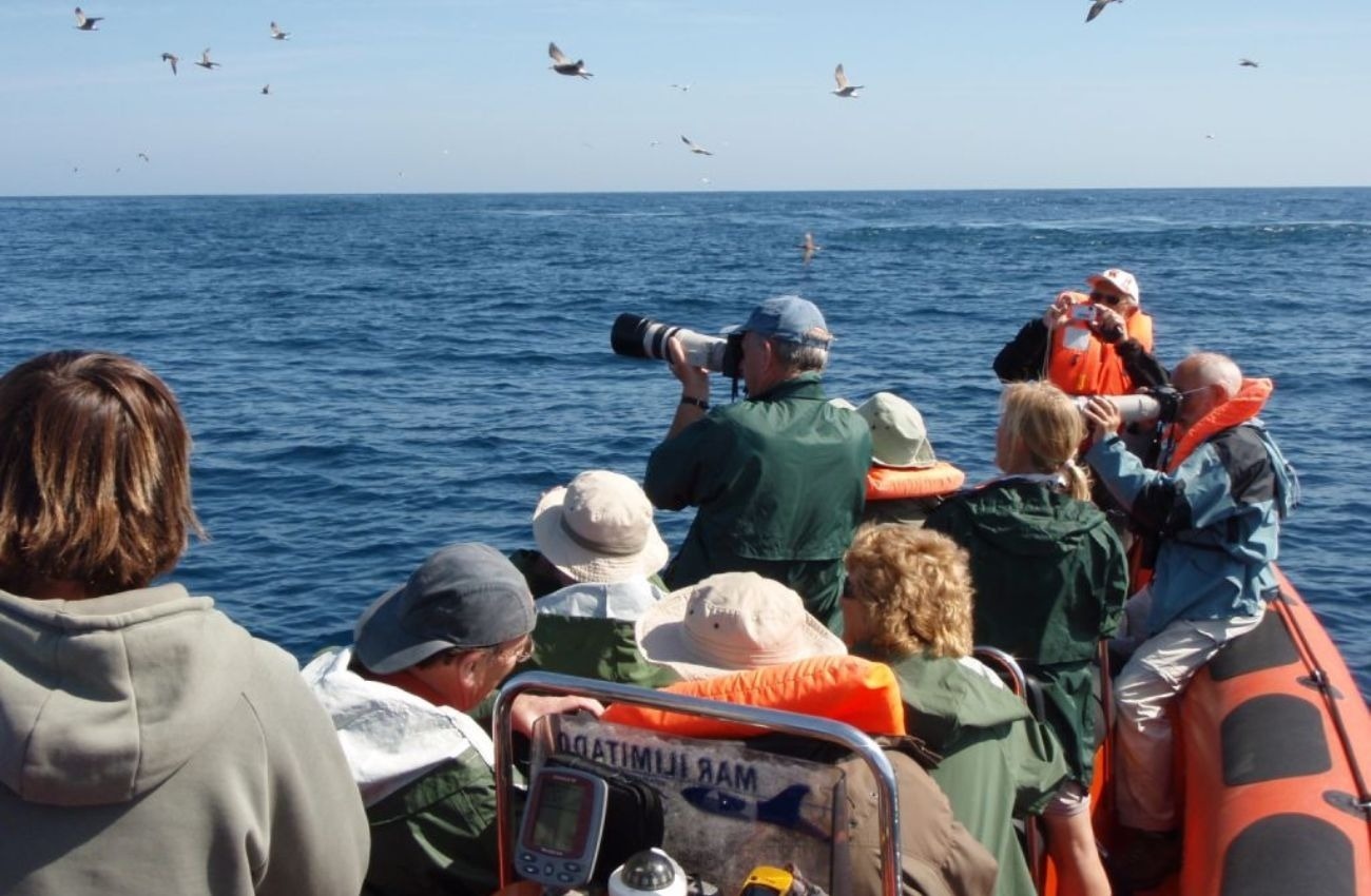 um grupo de pessoas está em um barco com uma placa que diz " boatimulam "