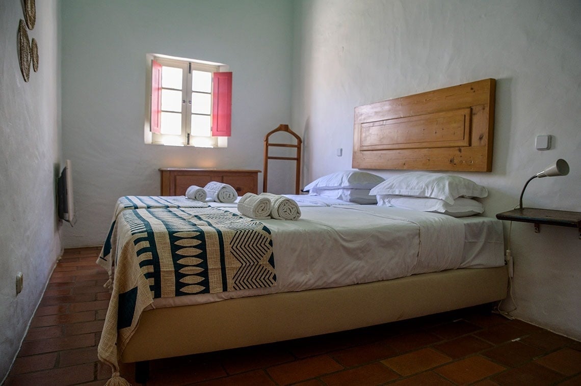 una habitación con una cama y una ventana con persianas rojas