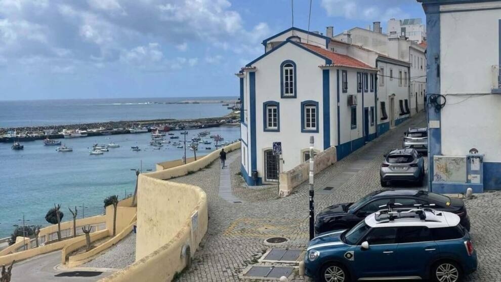 Vista de Aldeia da Pedralva com casas brancas, porto e carros.