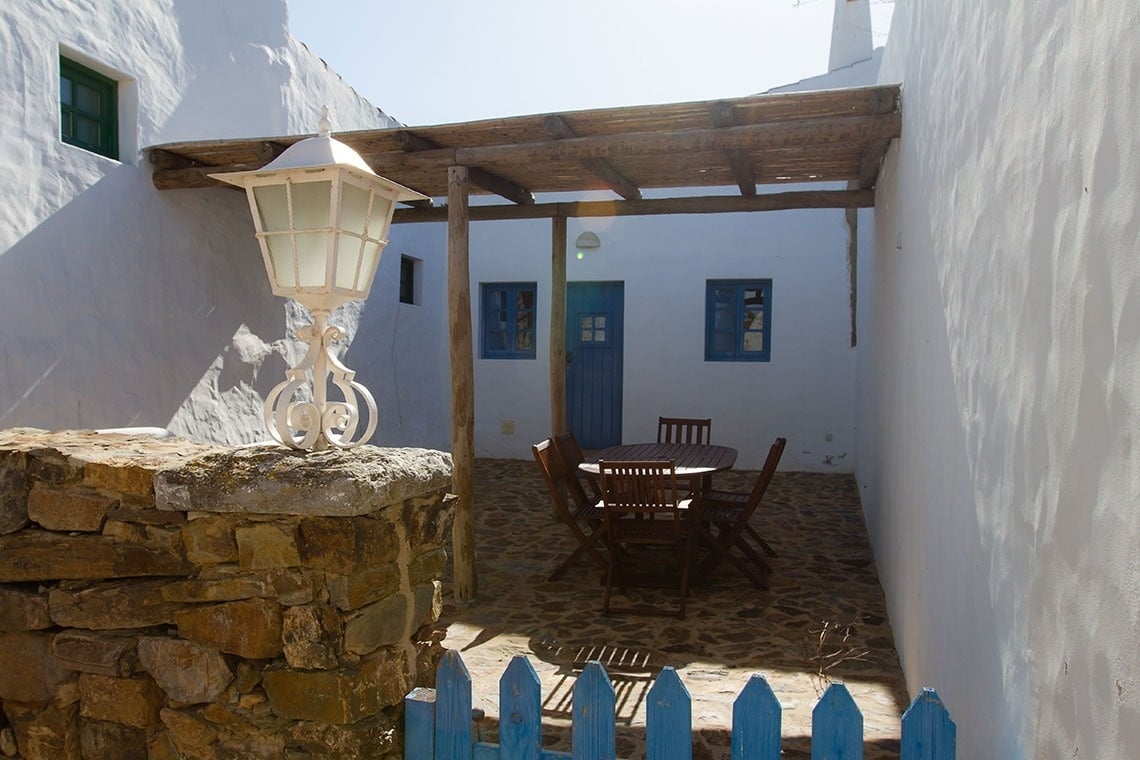 un patio con una mesa y sillas y una farola