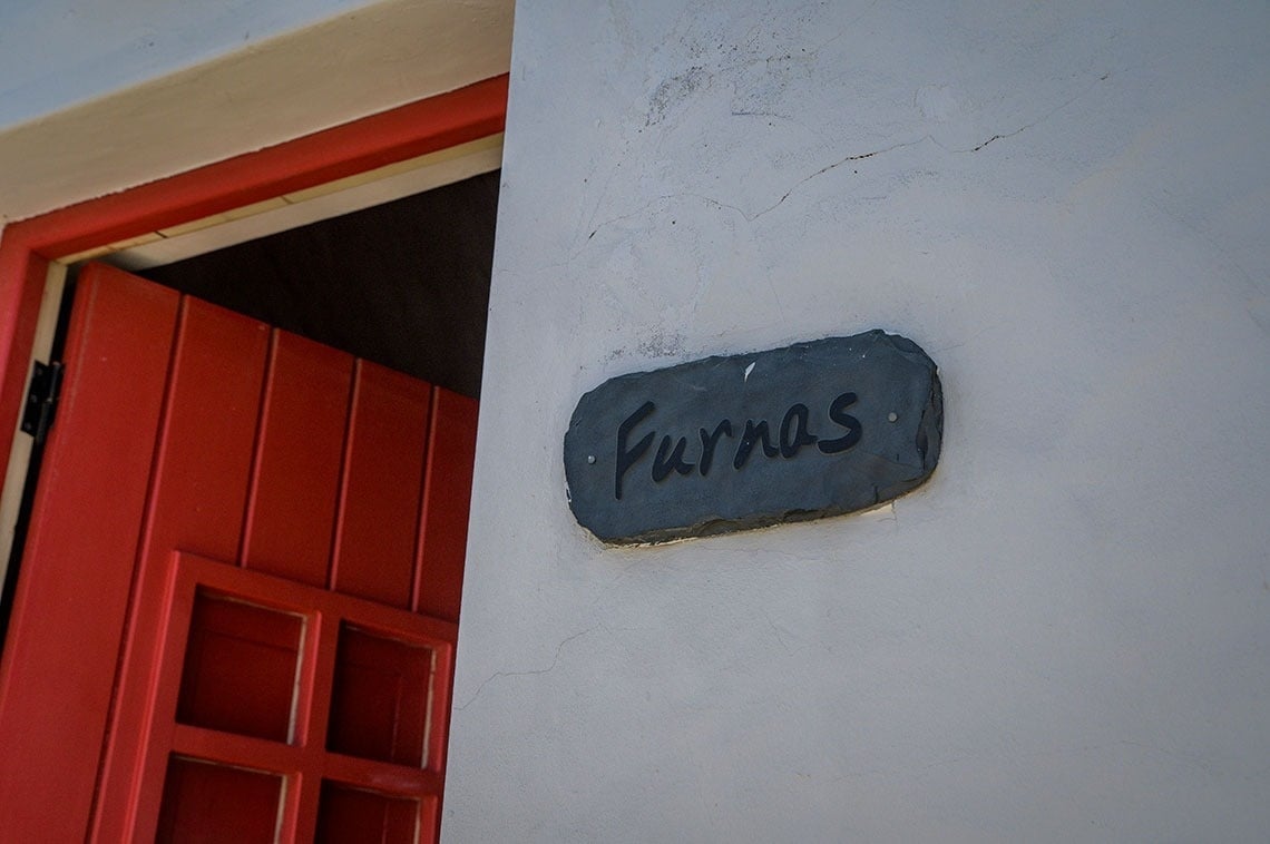 una puerta roja está abierta junto a una placa que dice furnas