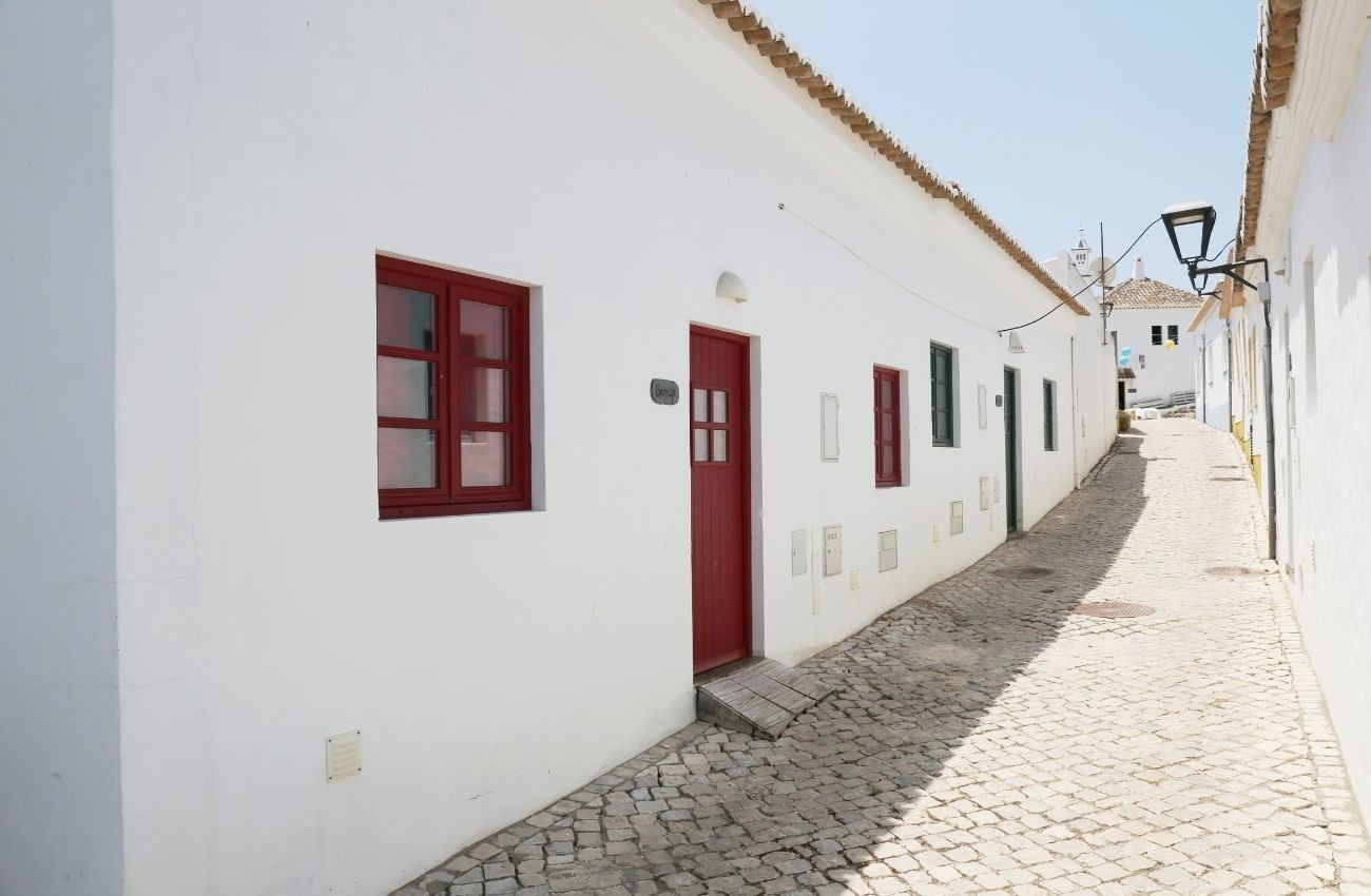 un edificio blanco con una puerta roja y una ventana