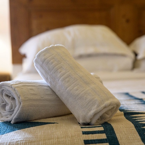 two white towels are rolled up on a bed