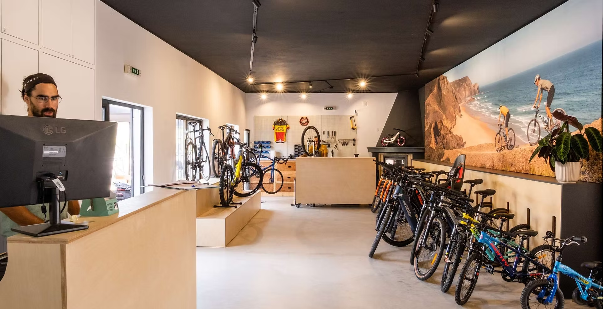un hombre frente a una pantalla de lg en una tienda de bicicletas