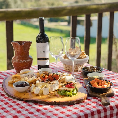 una mesa de picnic con una botella de vino com