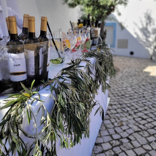 una mesa decorada con botellas de zum y copas de vino