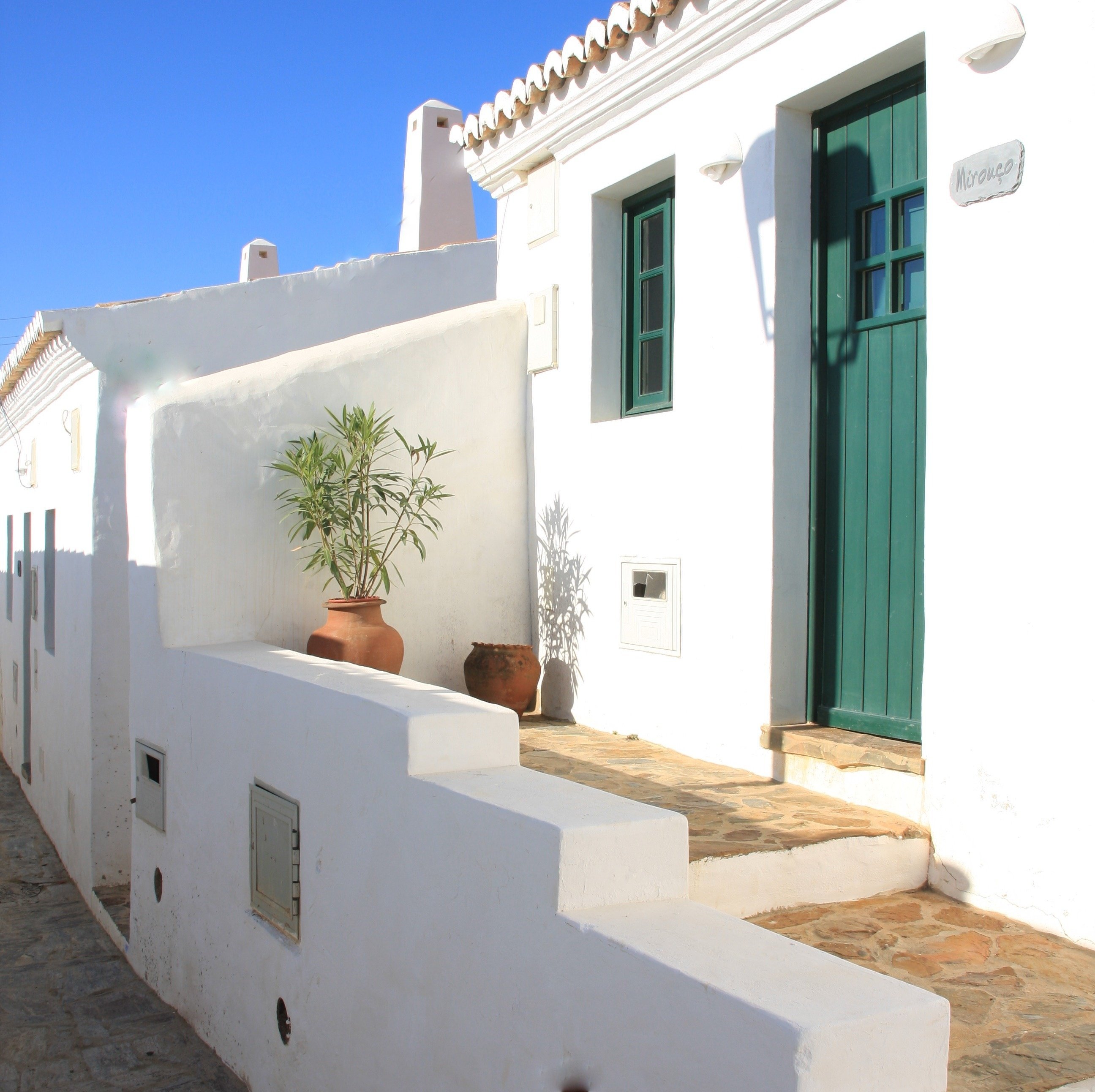 una casa blanca con una puerta verde y un letrero que dice " avenida "