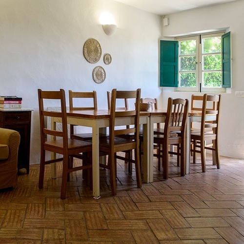 a dining room with a table and chairs and a stack of books on the table
