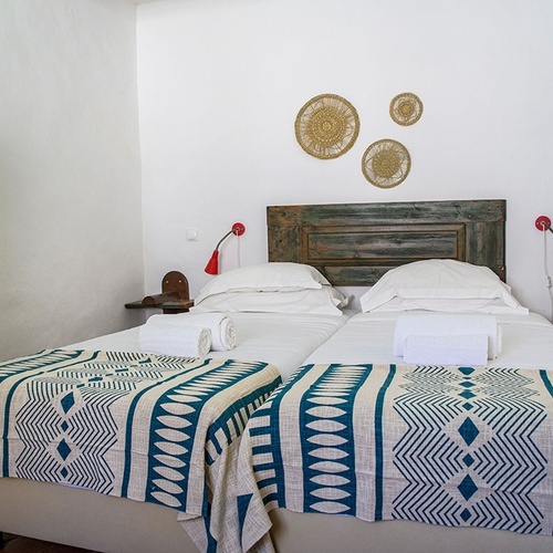 a bed with a blue and white blanket on it