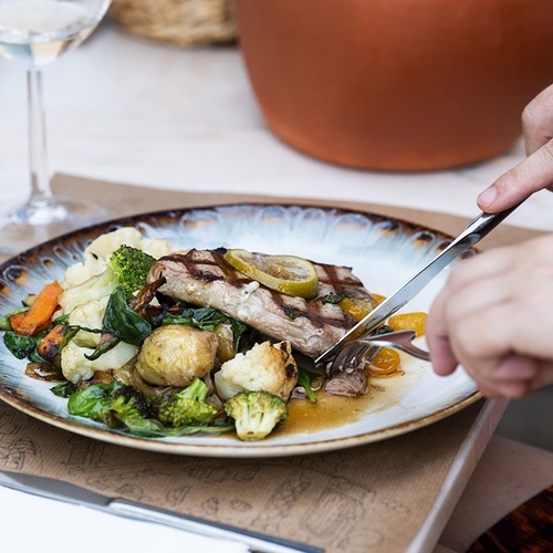 a plate of food with meat and vegetables on a table