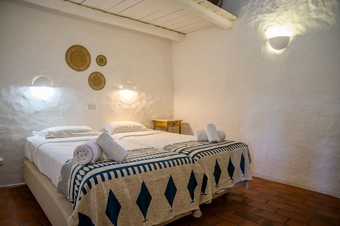 una habitación blanca con una cama y una mesita de noche