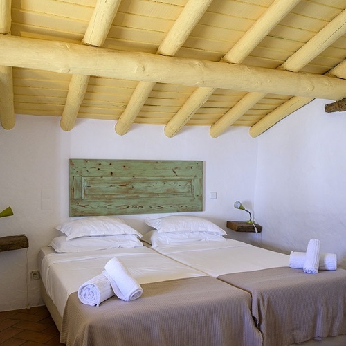 a bedroom with two beds and a wooden ceiling