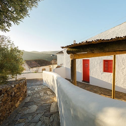 un edificio blanco con una puerta roja y una ventana