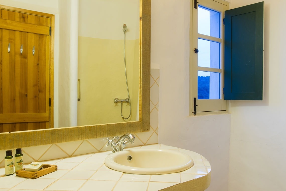 un baño con un lavabo y un espejo con persianas azules