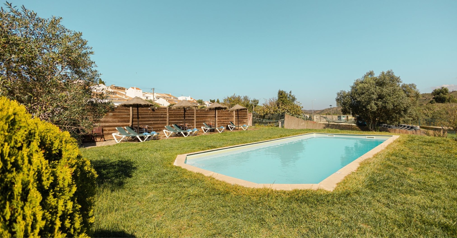 una piscina con sillas y sombrillas alrededor de ella