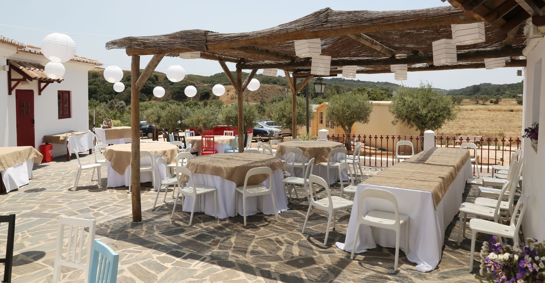 a patio with tables and chairs set up under a canopy