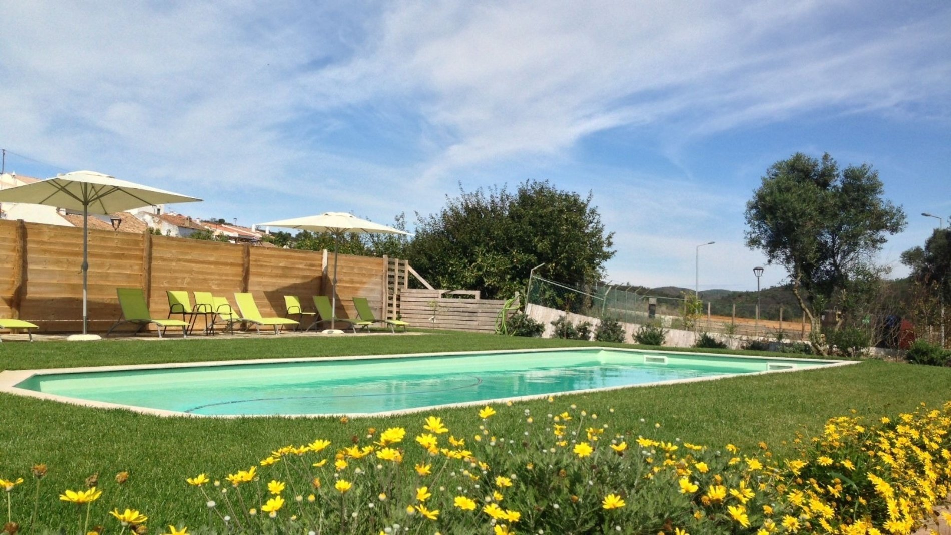 una piscina con sillas y sombrillas alrededor de ella