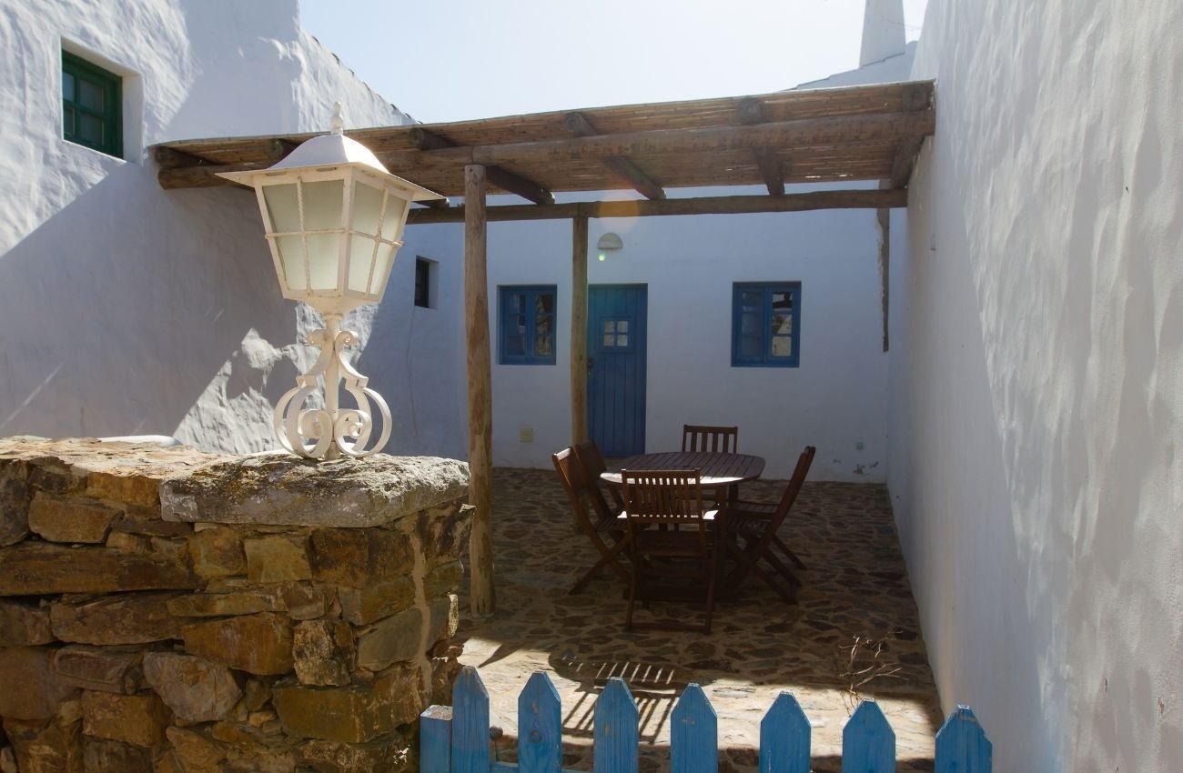 un patio con una mesa y sillas y una farola