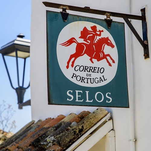 a sign on the side of a building that says correio de portugal selos