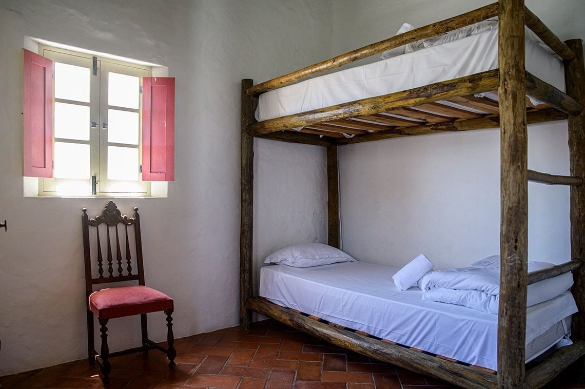 una litera de madera en una habitación junto a una silla