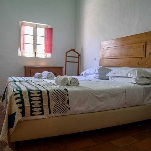 Aldeia da Pedralva twin beds with decorative throw and rolled towels.