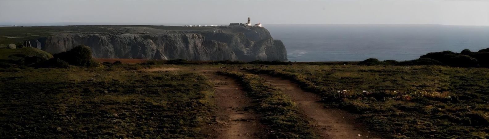 un hombre monta una bicicleta por un camino de tierra rodeado de árboles