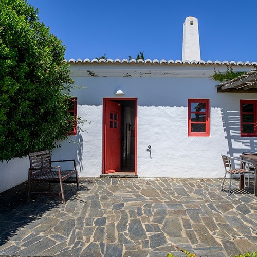 a white house with a red door and red windows