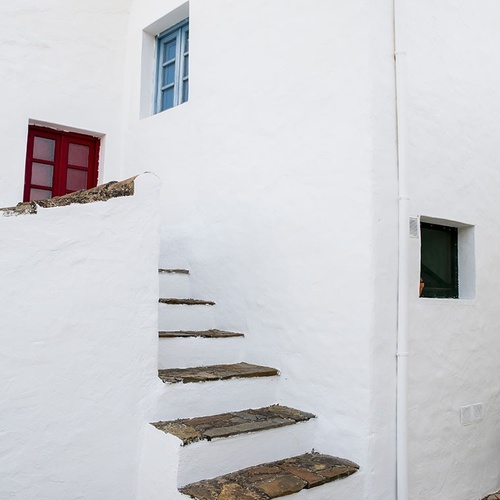 a white building with stairs leading up to a window