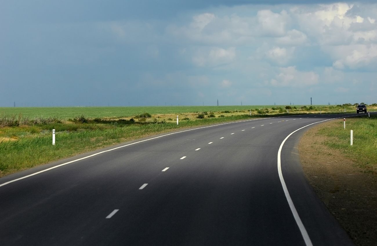 una carretera que conduce a través de un campo verde