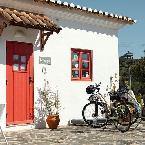 dos bicicletas están estacionadas frente a una puerta roja que dice recepção