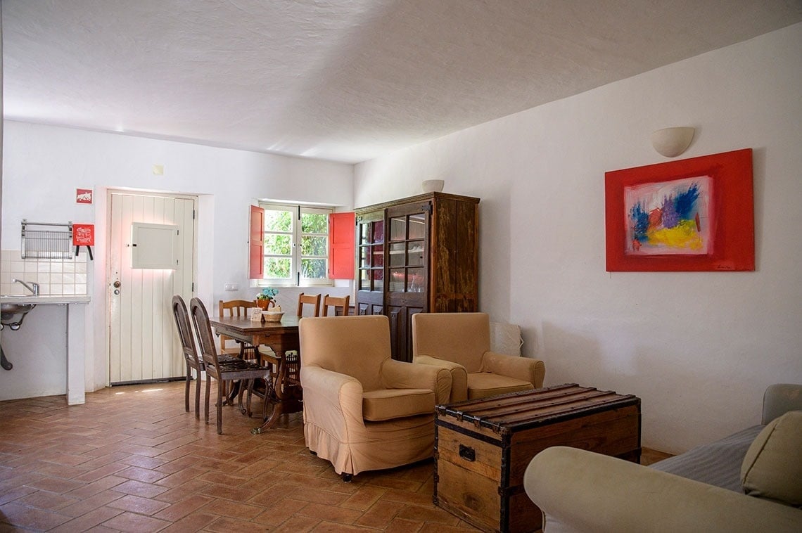 una sala de estar con una mesa y sillas y una pintura en la pared