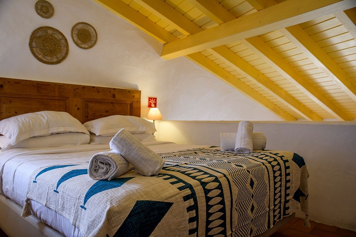 um quarto branco com uma cama e uma janela