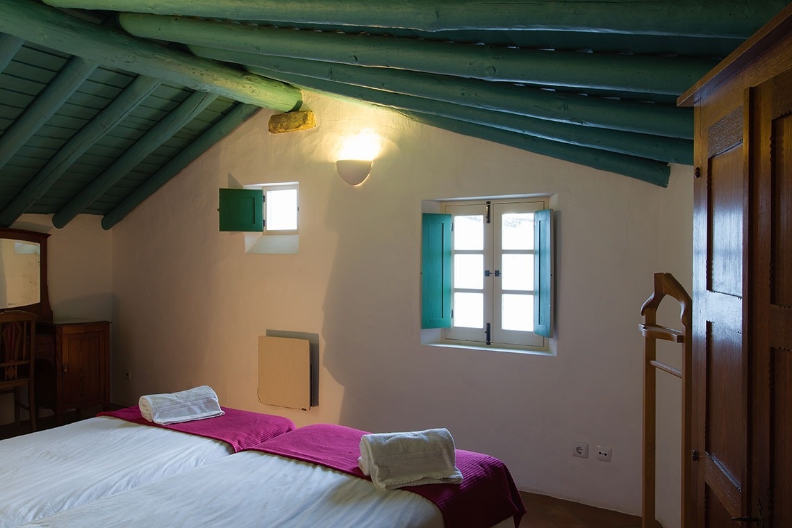 una habitación con una cama y una ventana con persianas azules