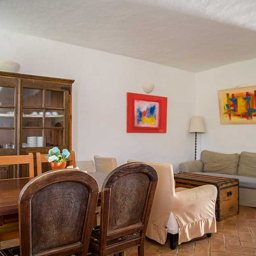 Aldeia da Pedralva dining room with rustic furniture, art, and a cozy living area.