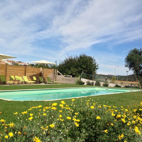 a large swimming pool surrounded by chairs and umbrellas