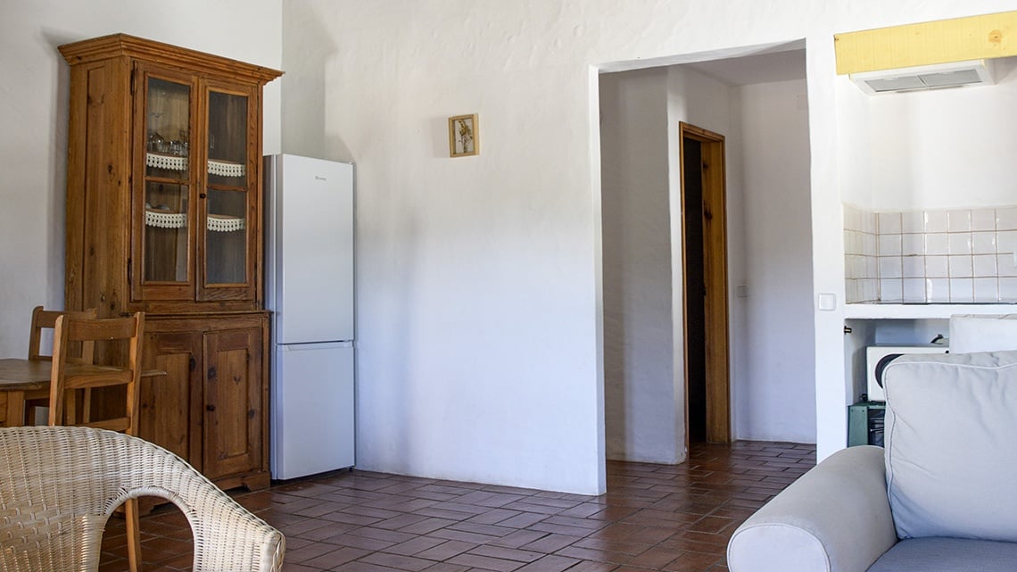 Apartamento charmoso na Aldeia da Pedralva com móveis rústicos e cozinha.